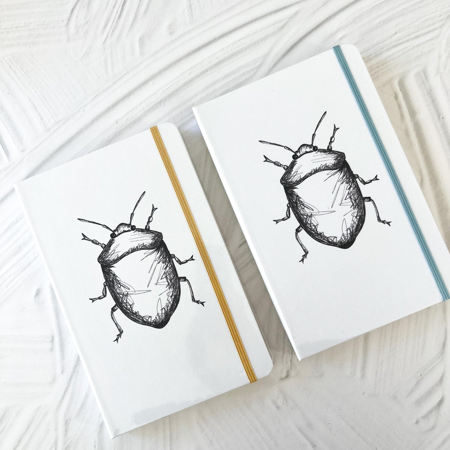 Foto de libreta con dibujo de escarabajo con las dos opciones de cinta