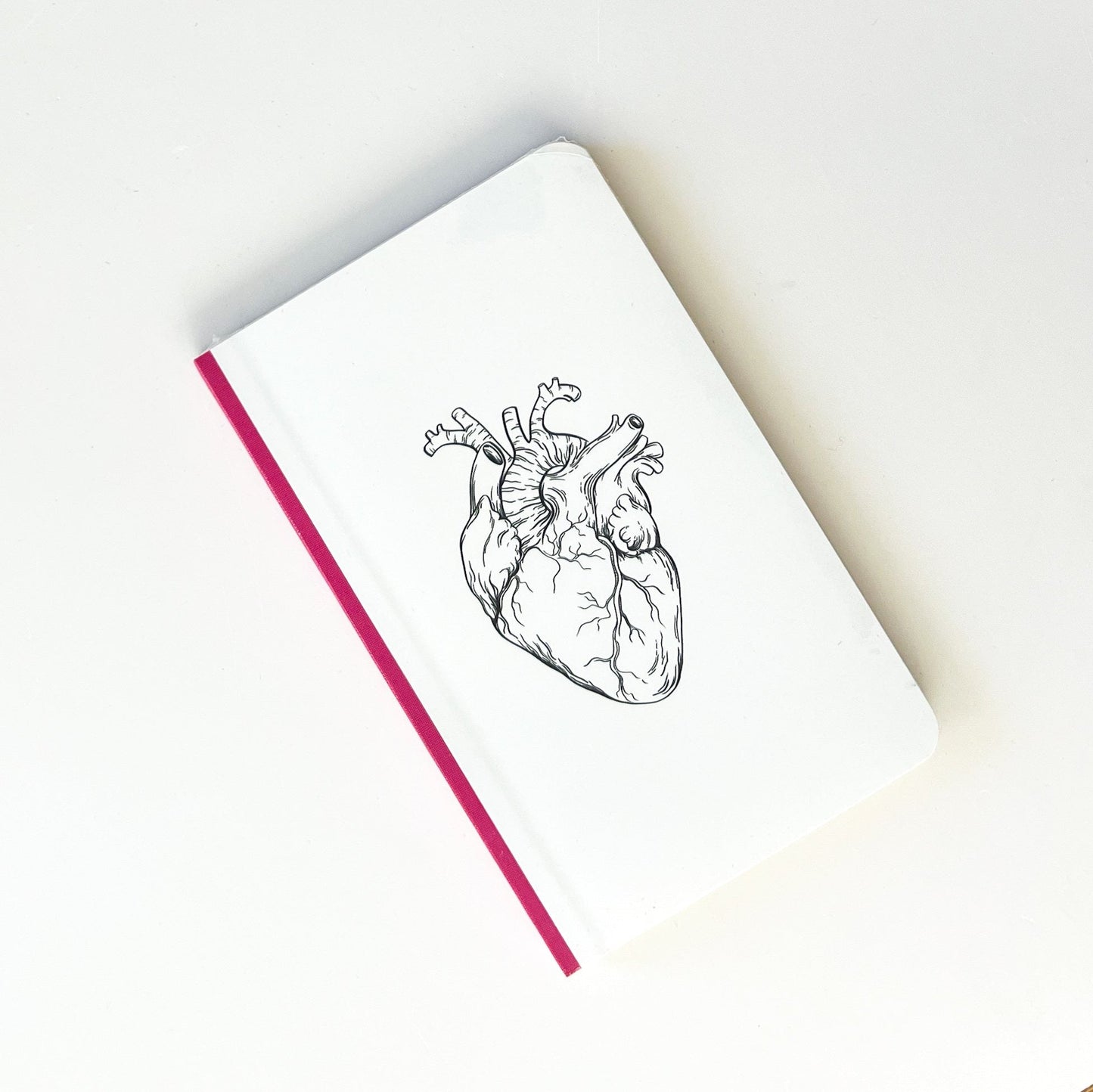 Foto de libreta con dibujo de corazón y lomo rosa