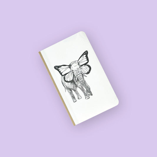 Foto de libreta con dibujo de un elefante con orejas de mariposa con fondo