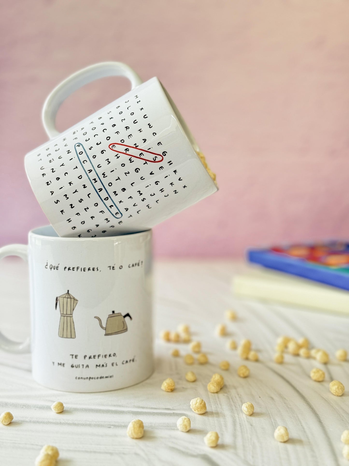 Foto de dos tazas de porcelana con sopa de letras Eres Poca Madre y ¿Qué prefieres, té o café?