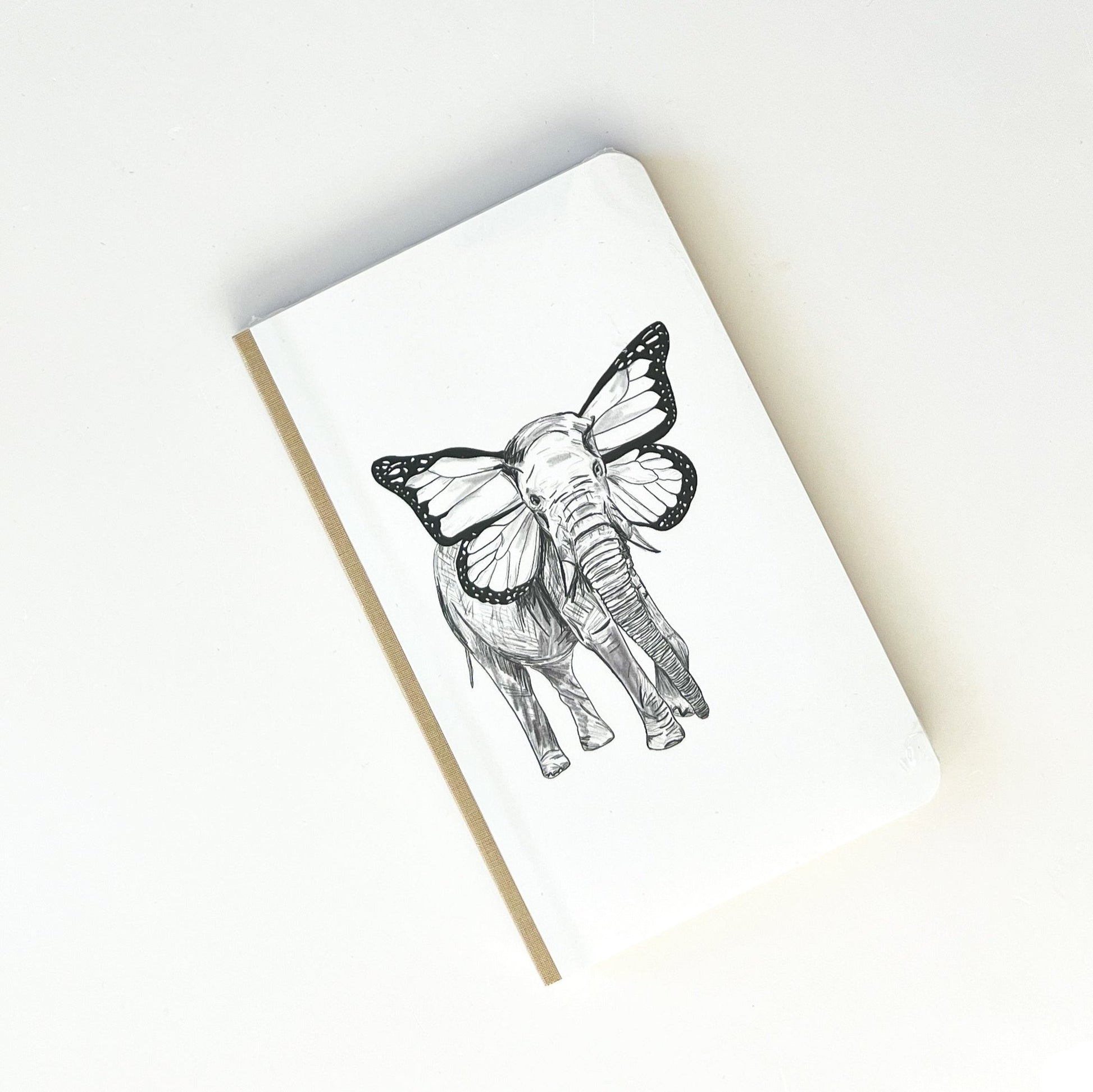 Foto de libreta con dibujo de un elefante con orejas de mariposa