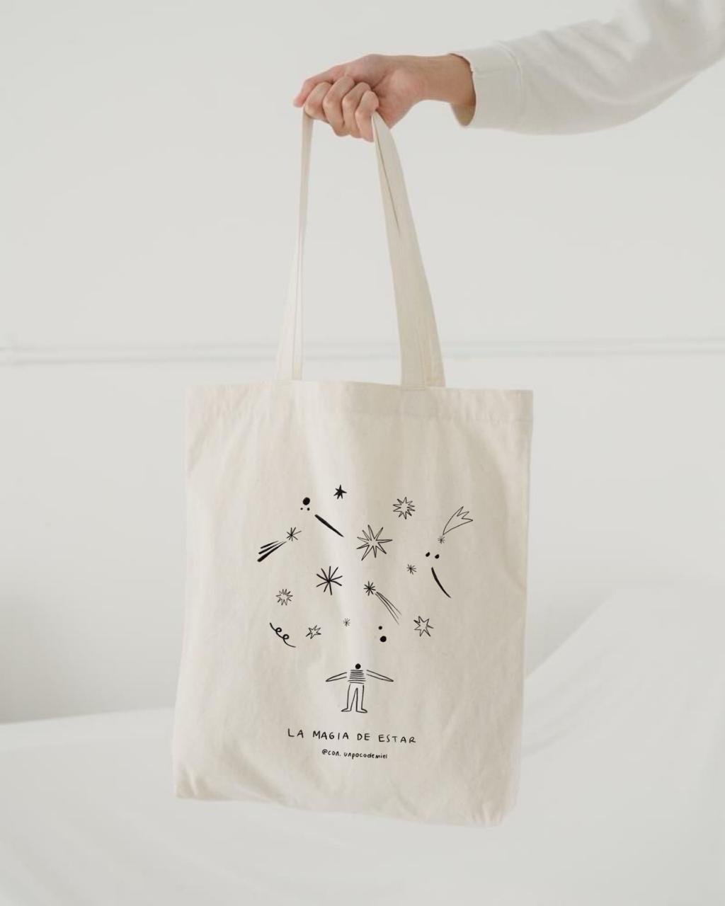 Foto de totebag con dibujo de la magia de estar con fondo azul